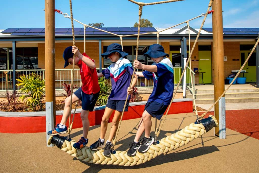 Three children play on a playground